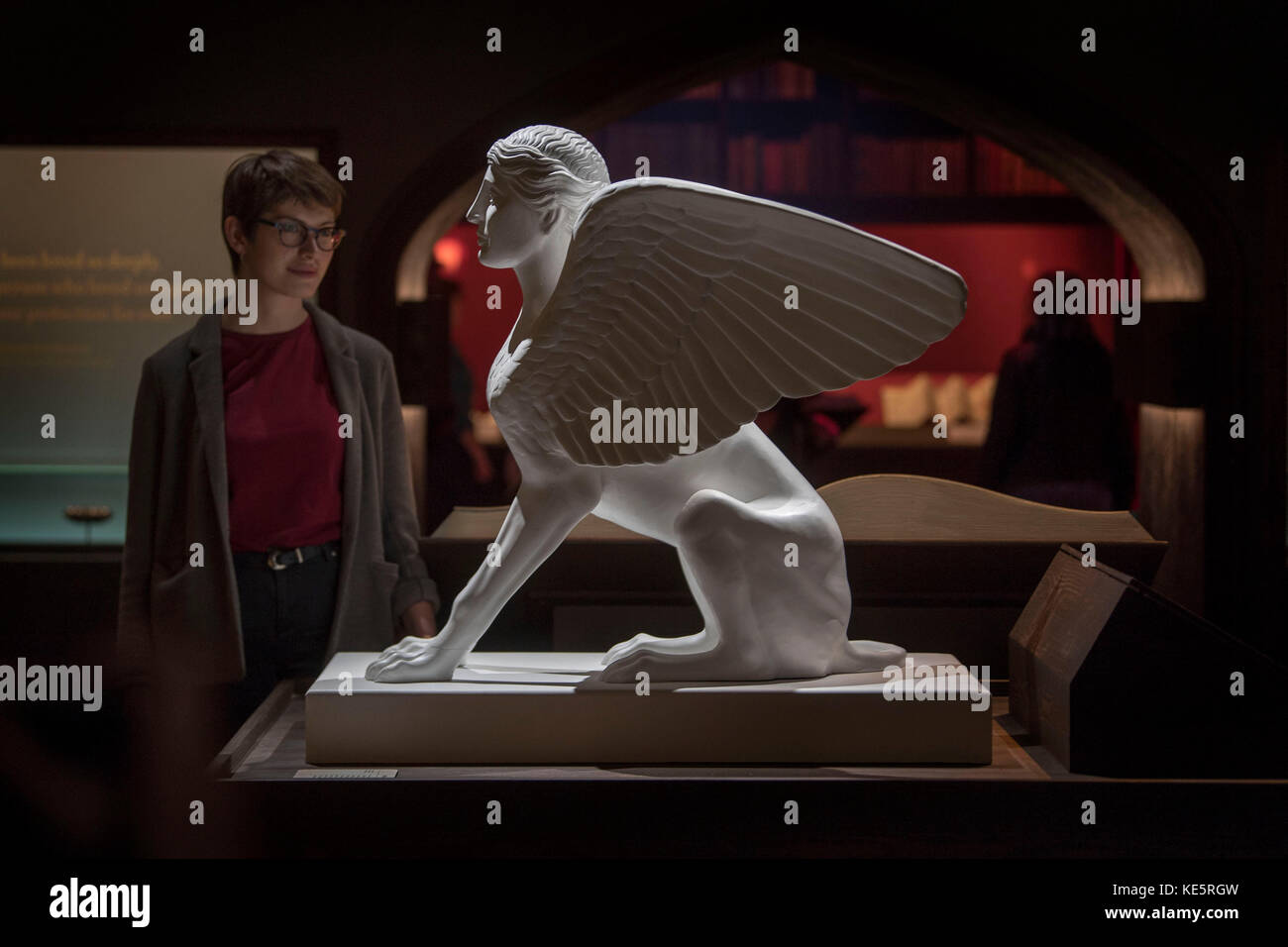 A visitor looks at a replica of a Sphinx made in AD 120-140 which represents Harry Potter's encounter with a Sphinx in 'The Goblet of Fire' during a press preview for the Harry Potter: A History of Magic exhibition at the British Library in London. Stock Photo