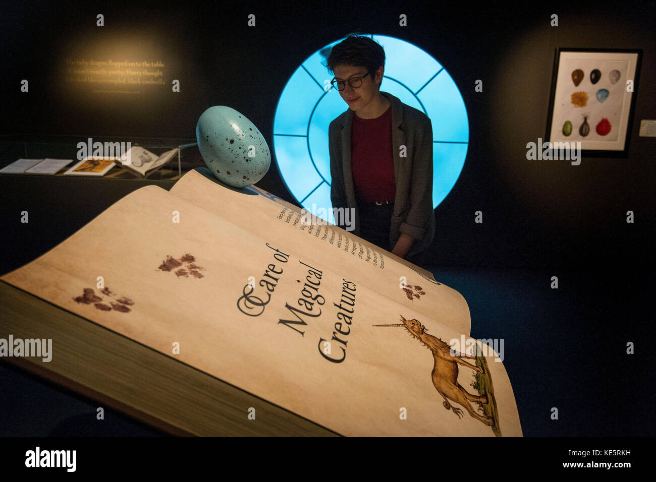 A visitor looks at a book of 'Care of Magical Creatures' during a press preview for the Harry Potter: A History of Magic exhibition at the British Library in London. Stock Photo