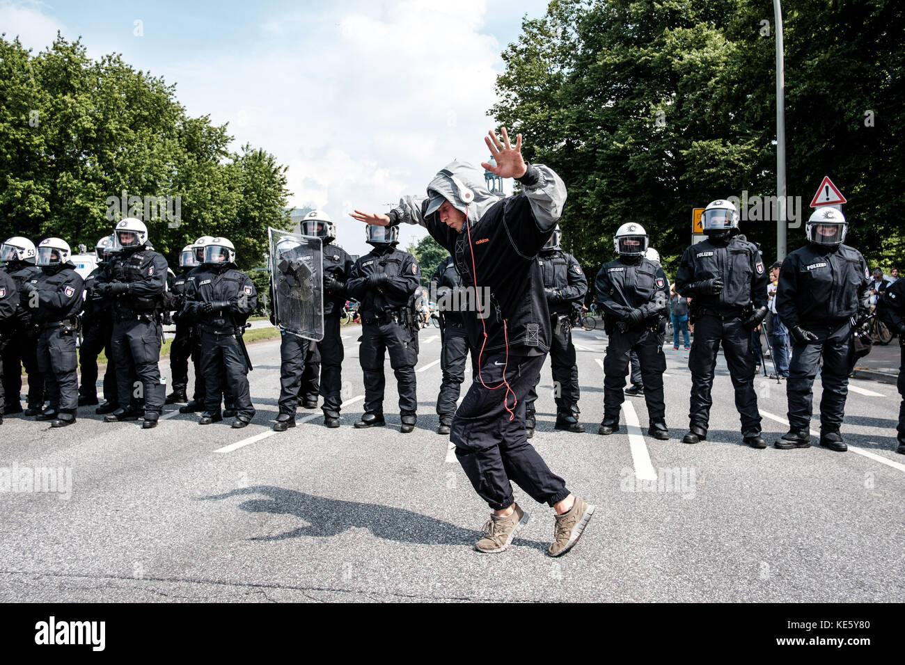 HAMBURG, JULY 7, 2017: Guy dance in front of policemen to demonstrate against G20 summit in Hamburg, Germany. Stock Photo