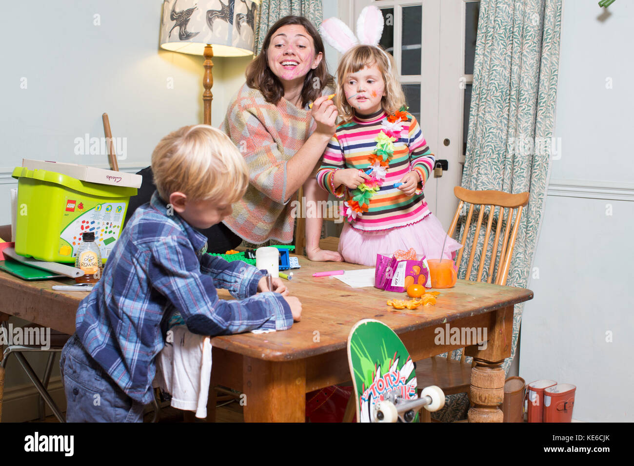 Mother and children practising a 'Yes Day' at home, new masochistic parenting trend, when parents agree to say 'yes' to all their children's requests. Stock Photo