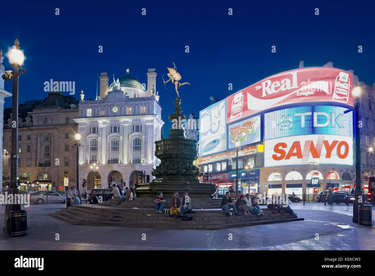 Piccadilly Circus in the West End of London.  Twilight, dusk and evening people waiting to meet friends under statue of Anteros by A Gilbert, London. Stock Photo