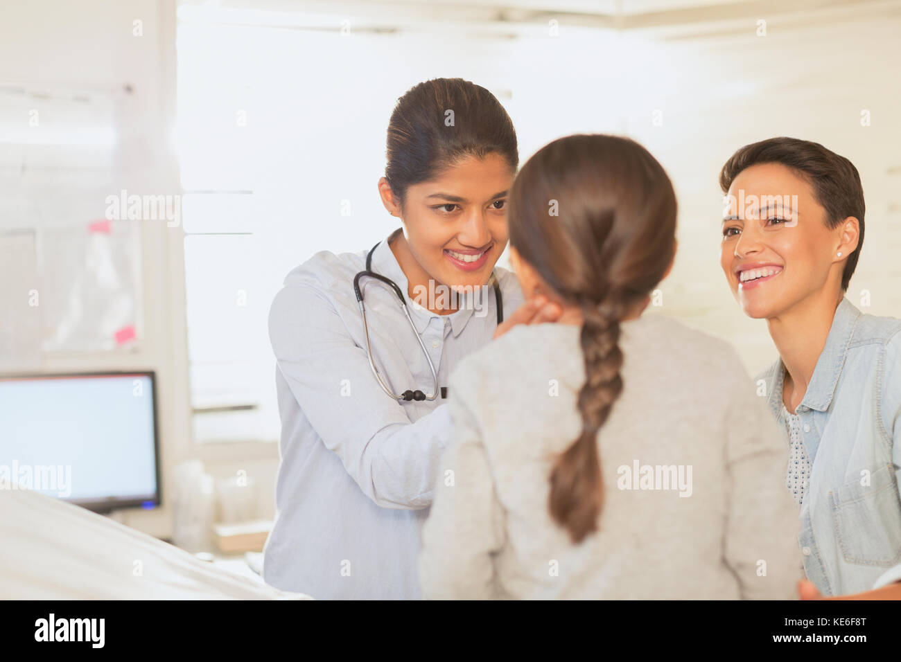 Female pediatrician checking neck lymph node glands of girl patient in examination room Stock Photo