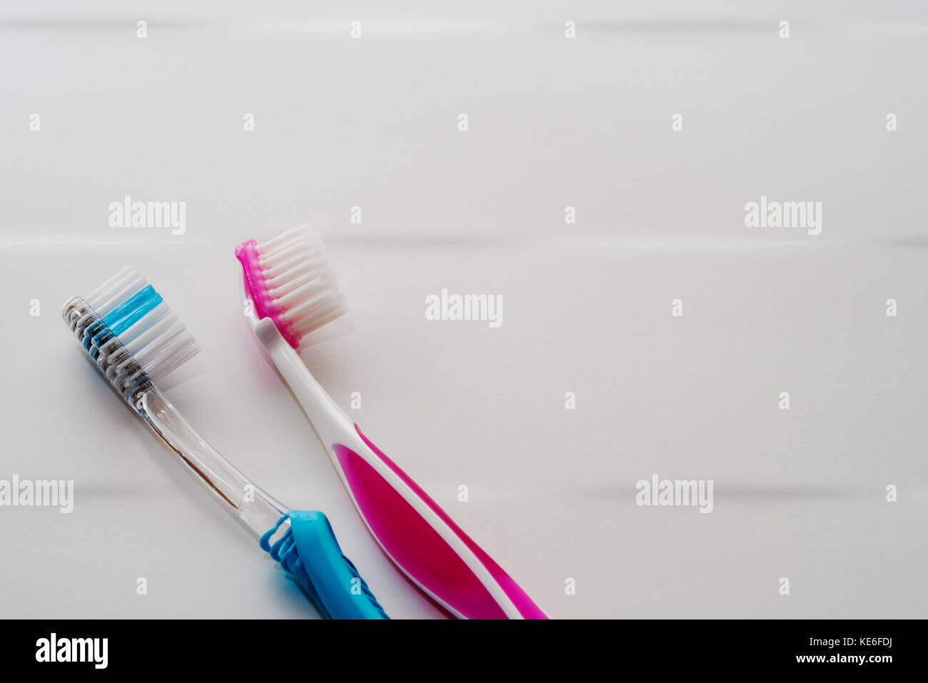 His and hers pink and blue toothbrushes. Stock Photo
