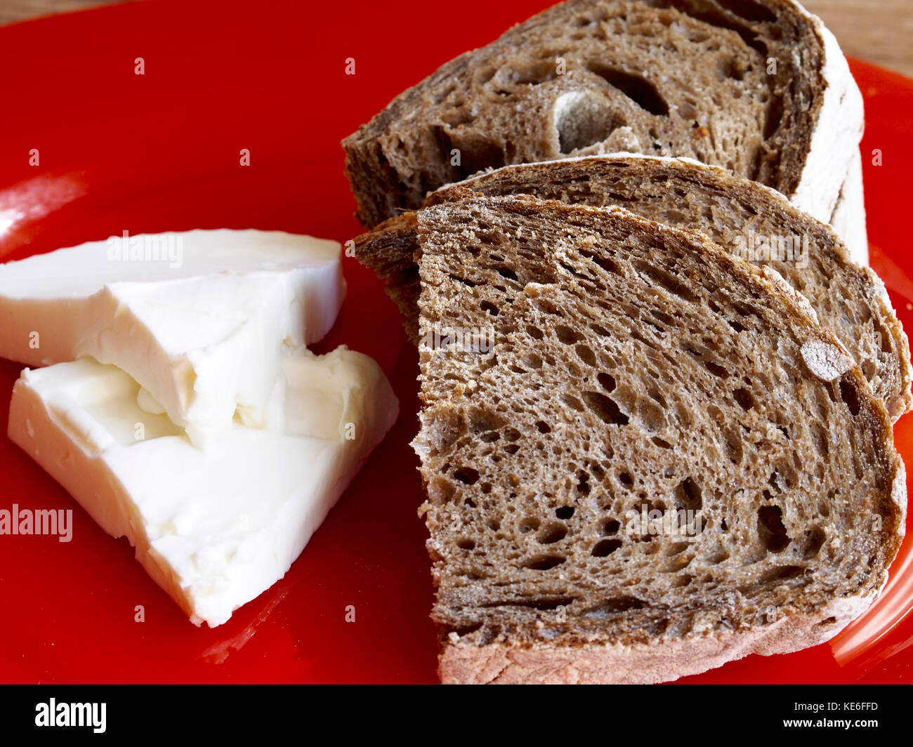 Malt rye bread with cheese on red plate Stock Photo Alamy