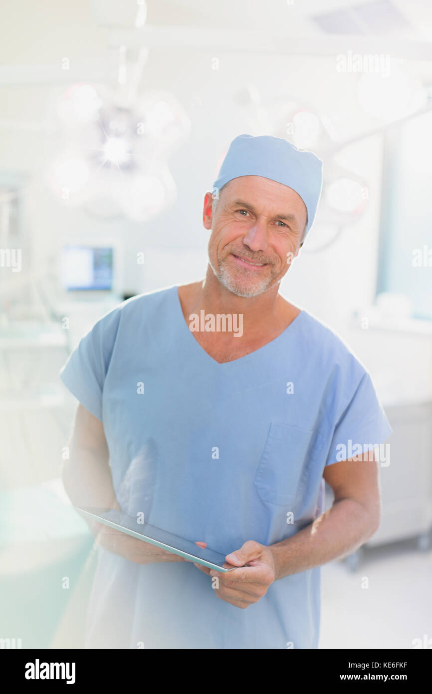 Portrait male surgeon using digital tablet in operating room Stock ...