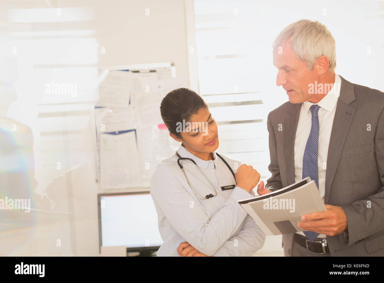 Female doctor and male hospital administrator reviewing paperwork Stock Photo