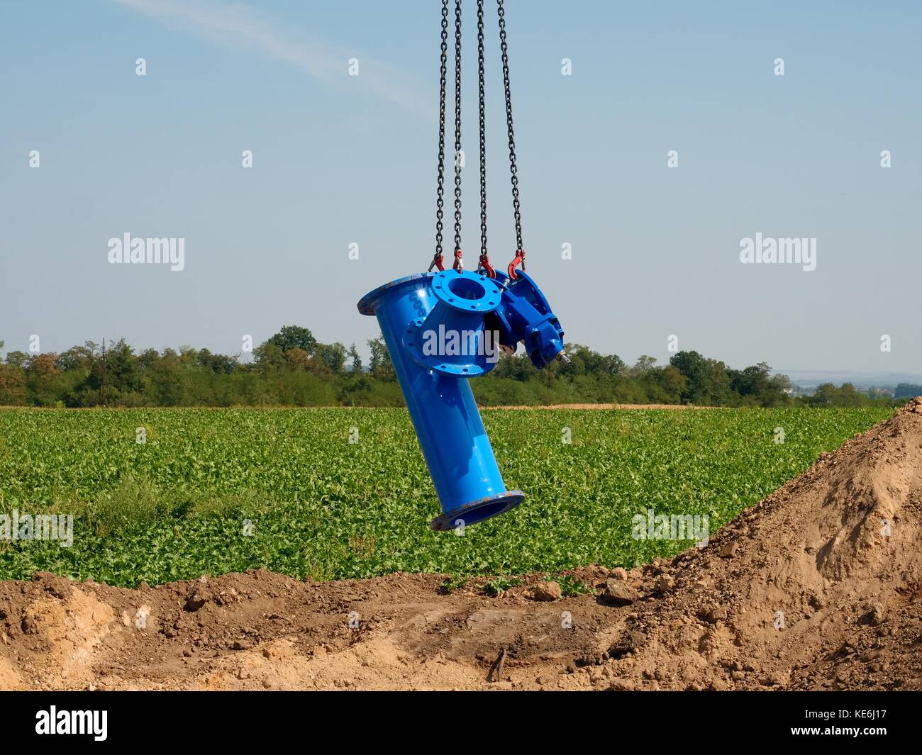 New pipeline part hanging on crane hook. Transport of gate valve within