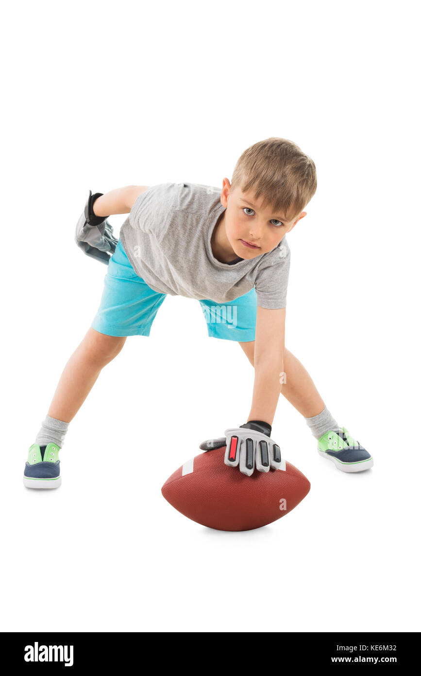 Portrait Of Boy Holding American Football Over White Background Stock Photo