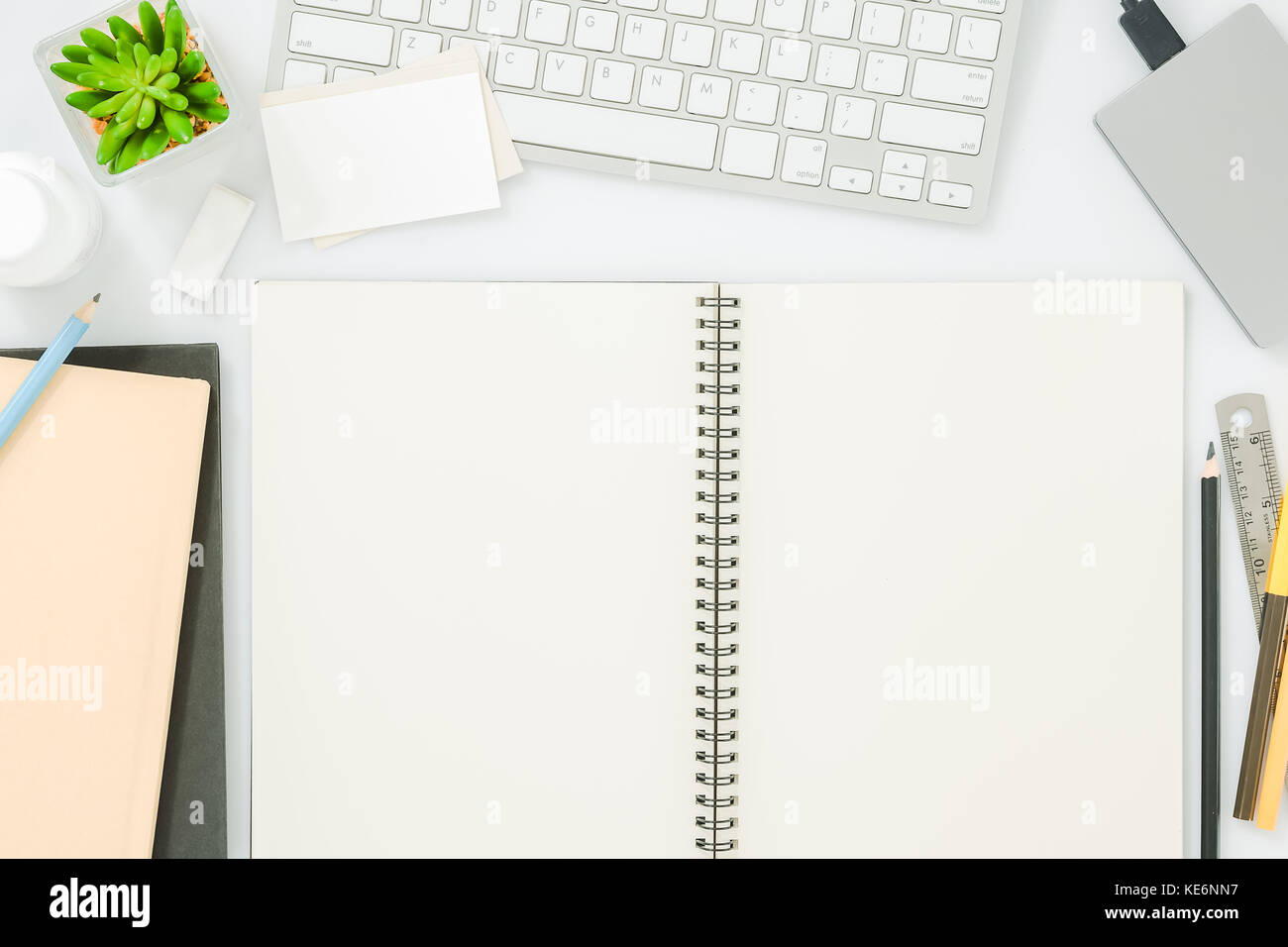 Empty notepad and modern smart phone mockup on white office desk surrounded  with office supplies. Top view. Flat lay Stock Photo - Alamy