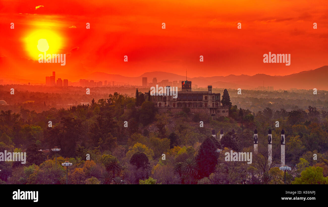 A breathtaking panoramic shot captures the enchanting silhouette of Chapultepec Castle in Mexico, bathed in the warm hues of the setting sun. Stock Photo