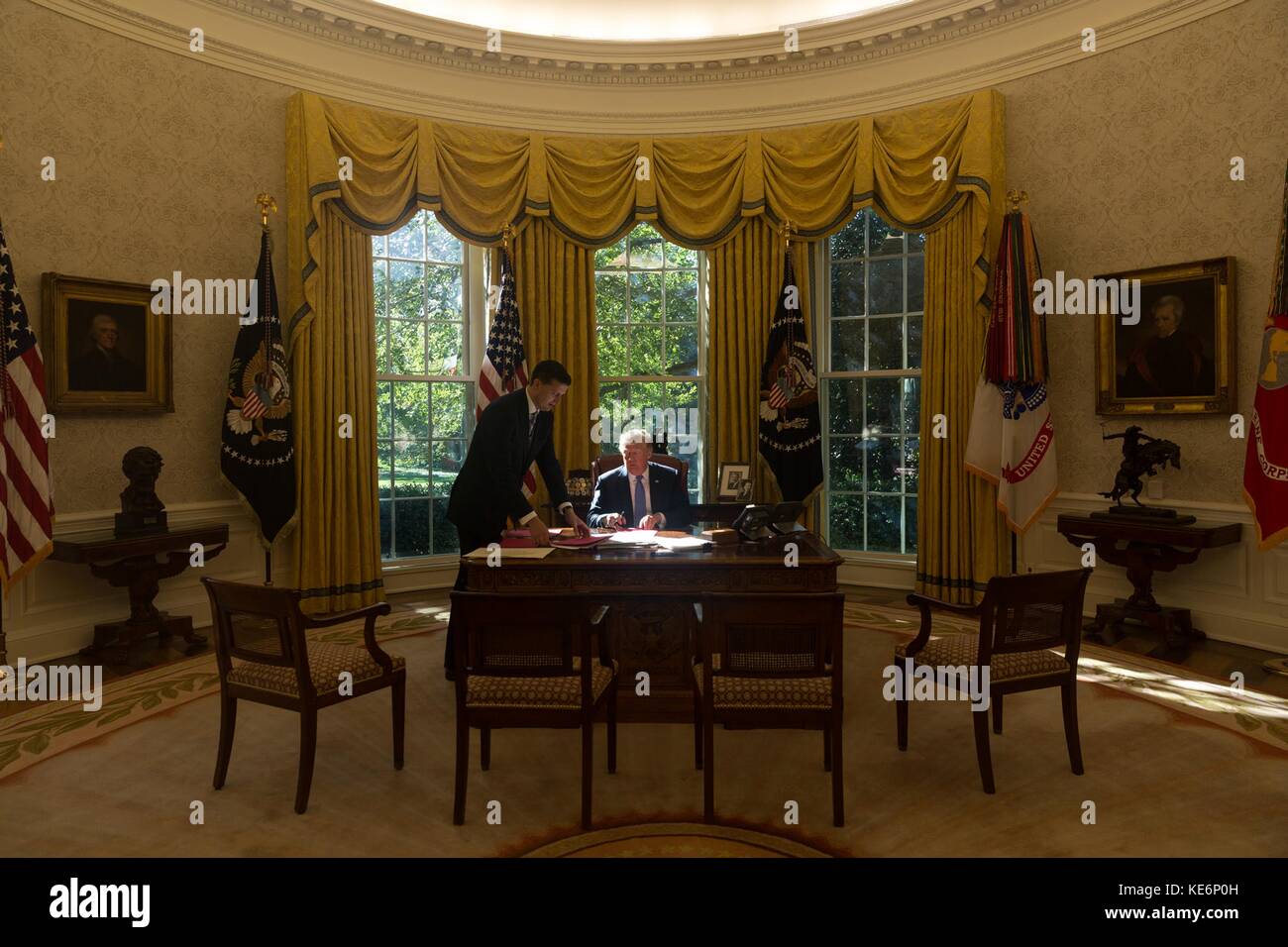 U.S. President Donald Trump signs documents in the Oval Office of the White House October 16, 2017 in Washington, D.C. Stock Photo
