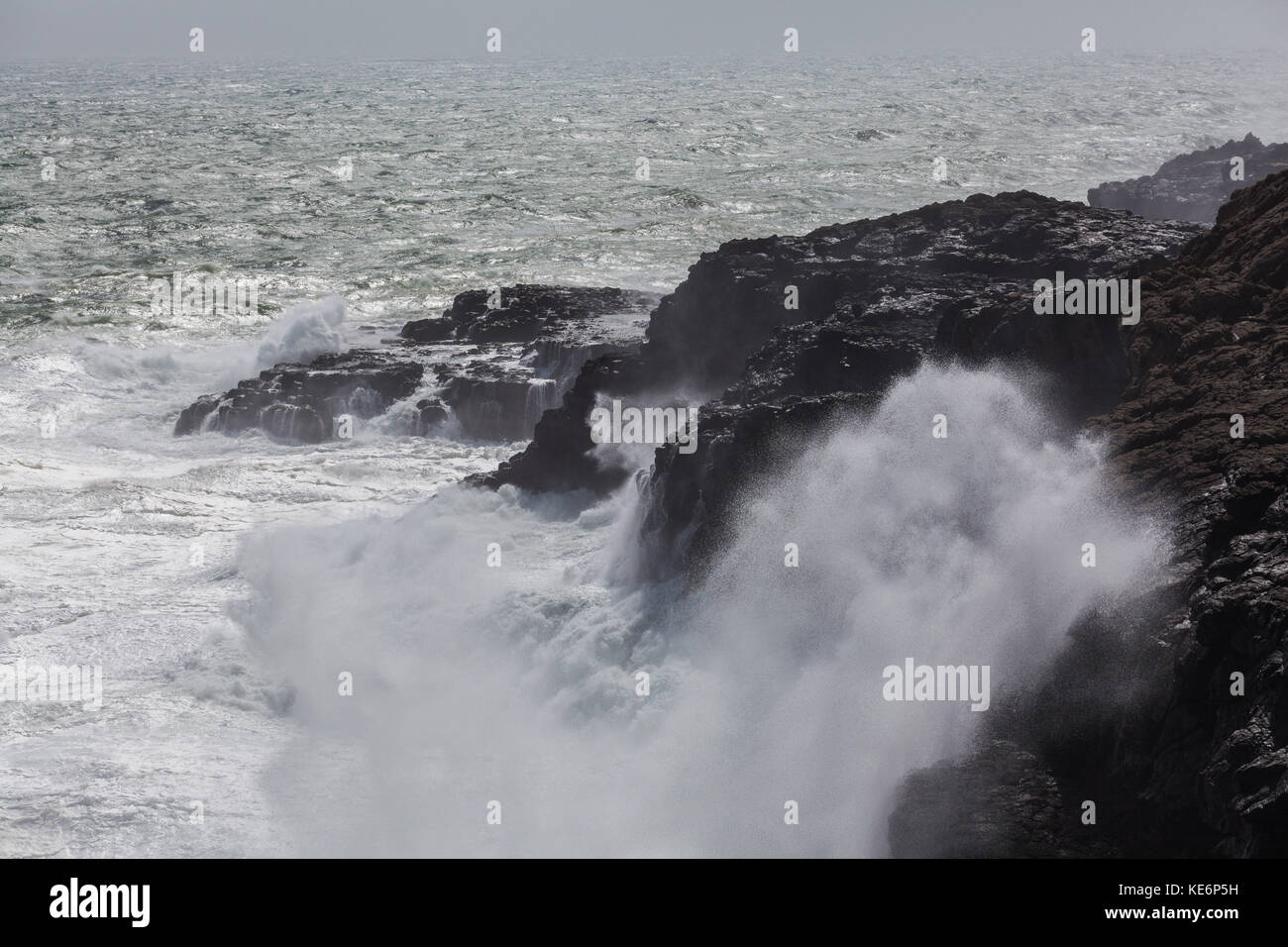 Waves breaking hard on rocks - extreme force of nature Stock Photo