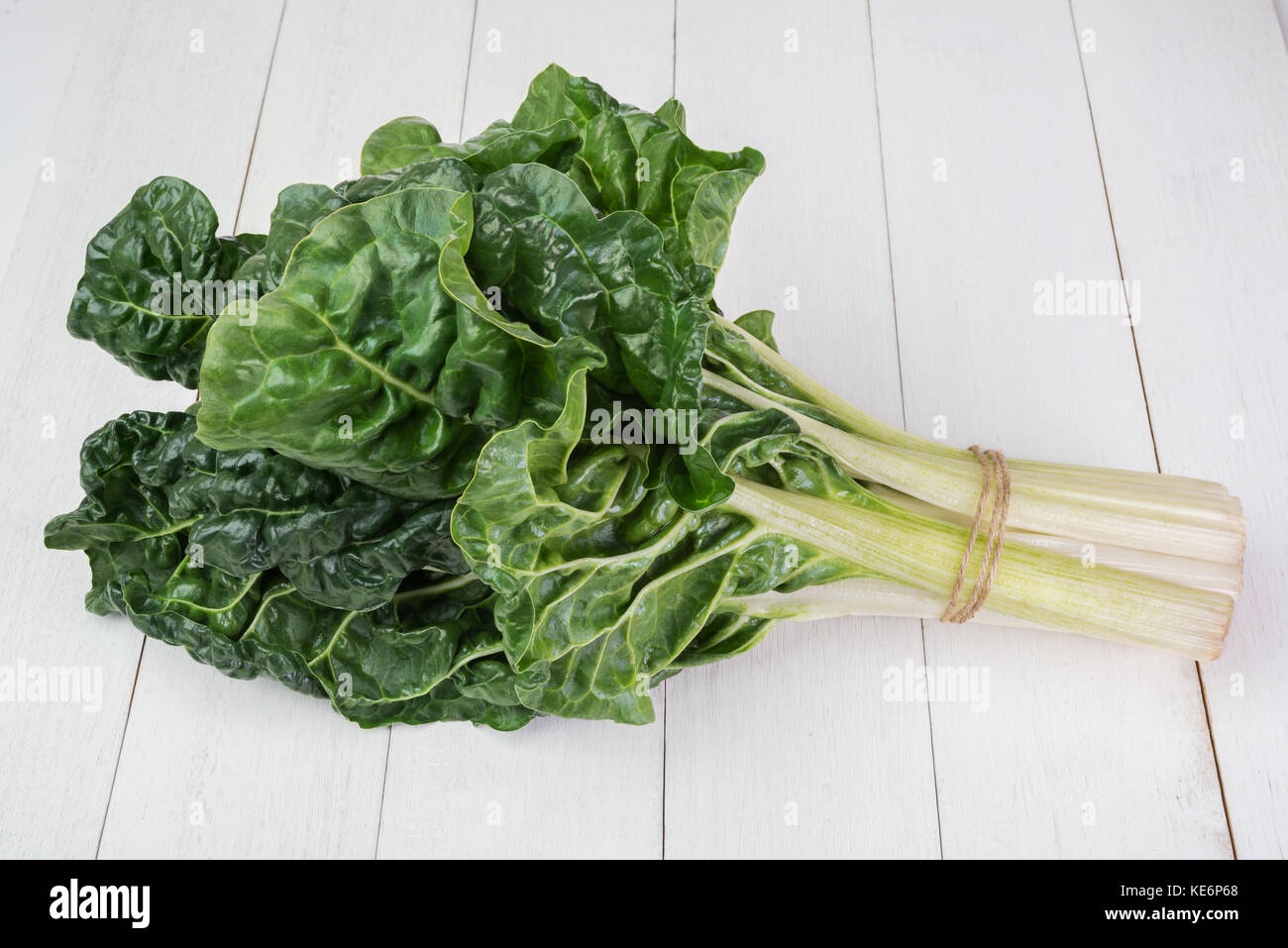 fresh green silverbeet leaves vegetable on  white wooden background Stock Photo