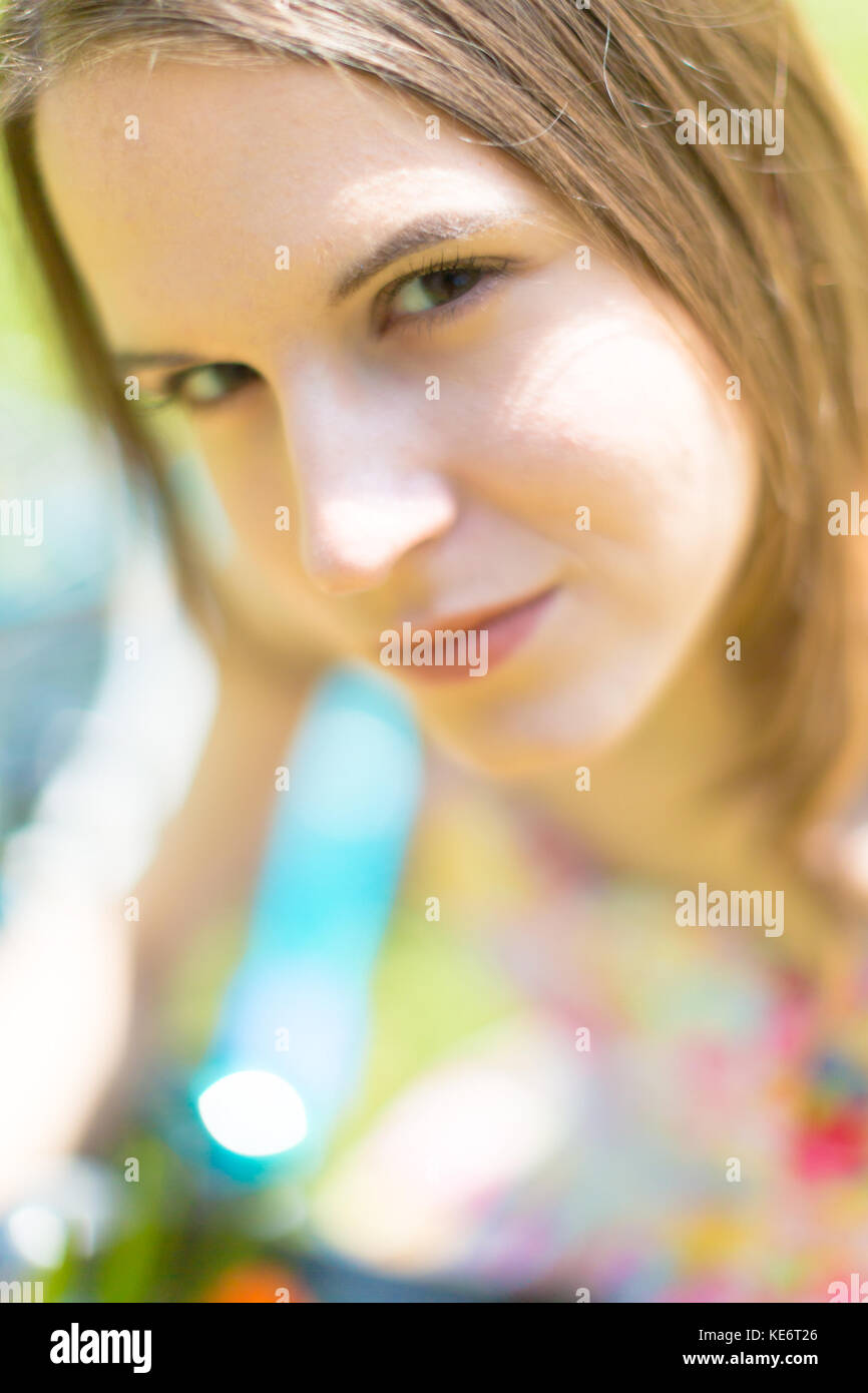 Portrait of a cute young woman with a bouquet of flowers in a summer ...