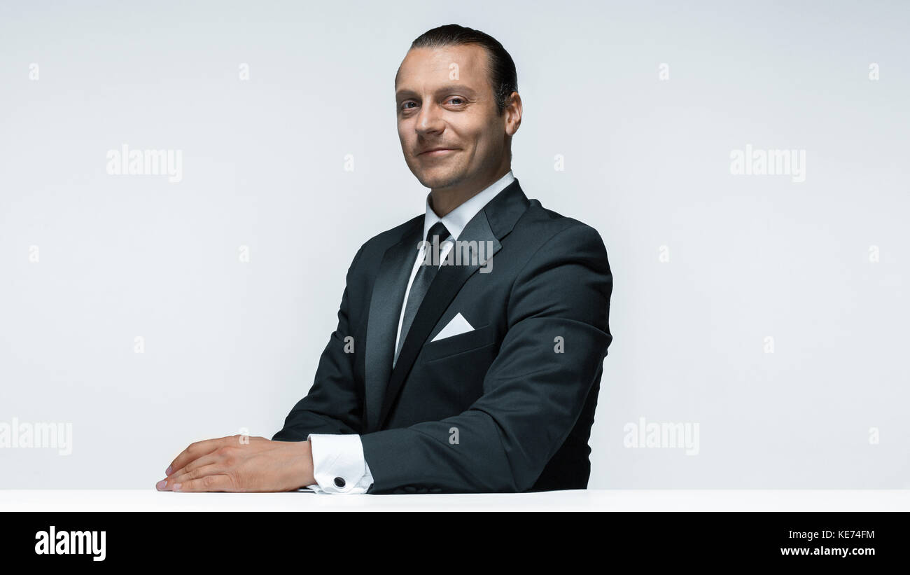 The attractive man in black suit on white background Stock Photo - Alamy