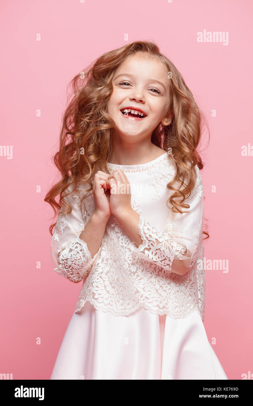 The beautiful little girl in dress standing and posing over white
