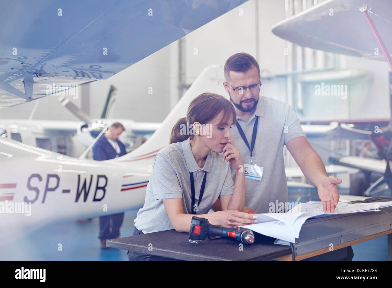 Airplane Mechanics Reviewing Plans In Hangar Stock Photo Alamy