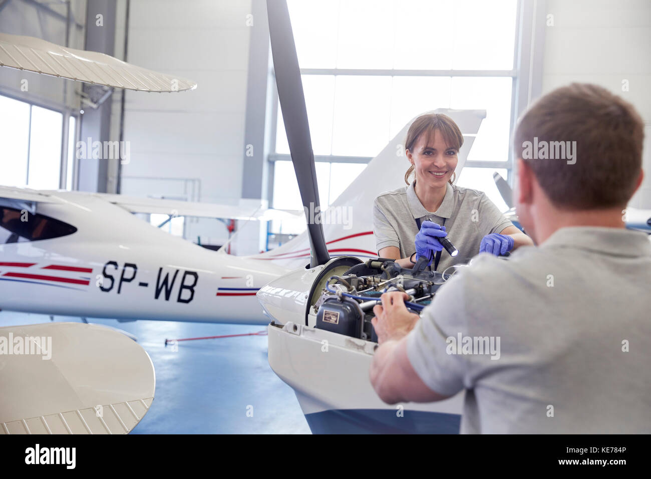 Airplane mechanics repairing engine in hangar Stock Photo