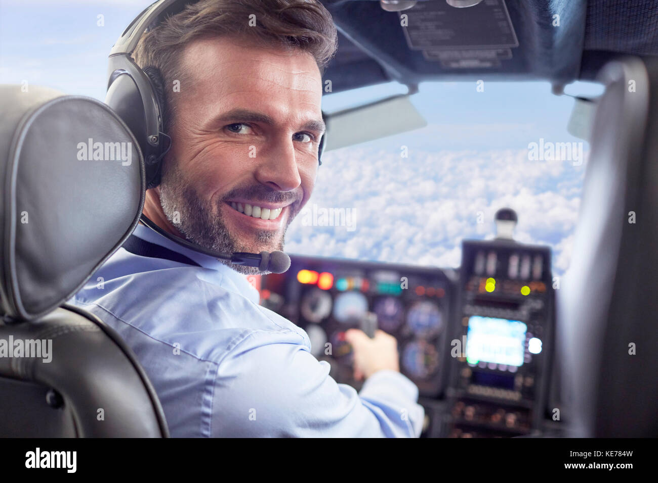 Portrait smiling, confident male pilot flying airplane in cockpit Stock Photo