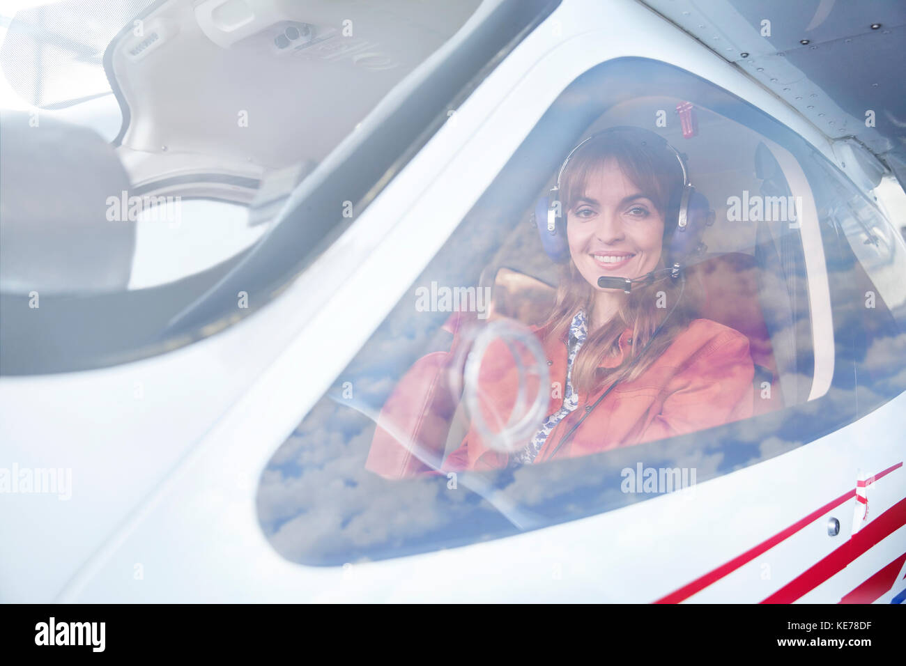 Portrait smiling female airplane pilot in cockpit Stock Photo