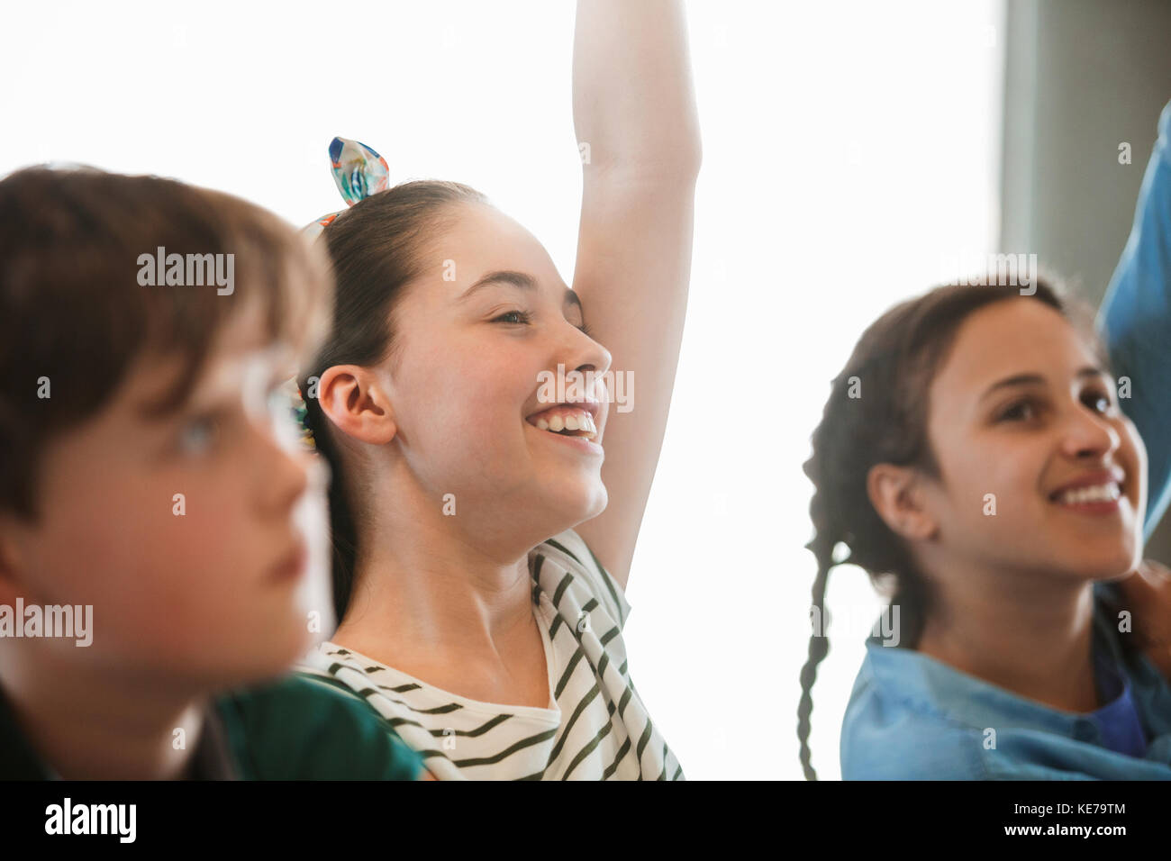 Smiling, eager girl student asking a question in classroom Stock Photo