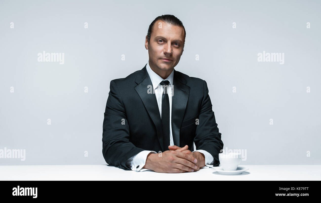 The attractive man in black suit on white background Stock Photo - Alamy