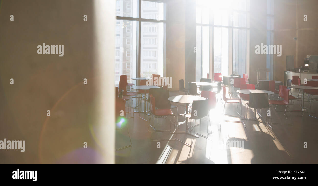 Sun shining on tables in school cafeteria Stock Photo