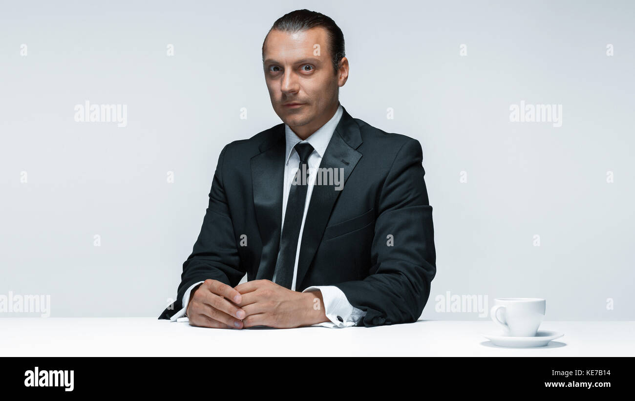 The attractive man in black suit on white background Stock Photo - Alamy