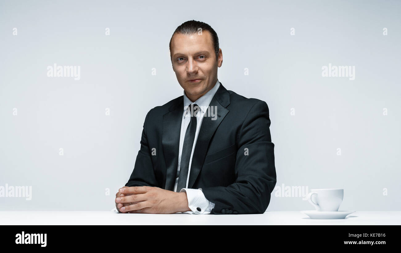 The attractive man in black suit on white background Stock Photo - Alamy