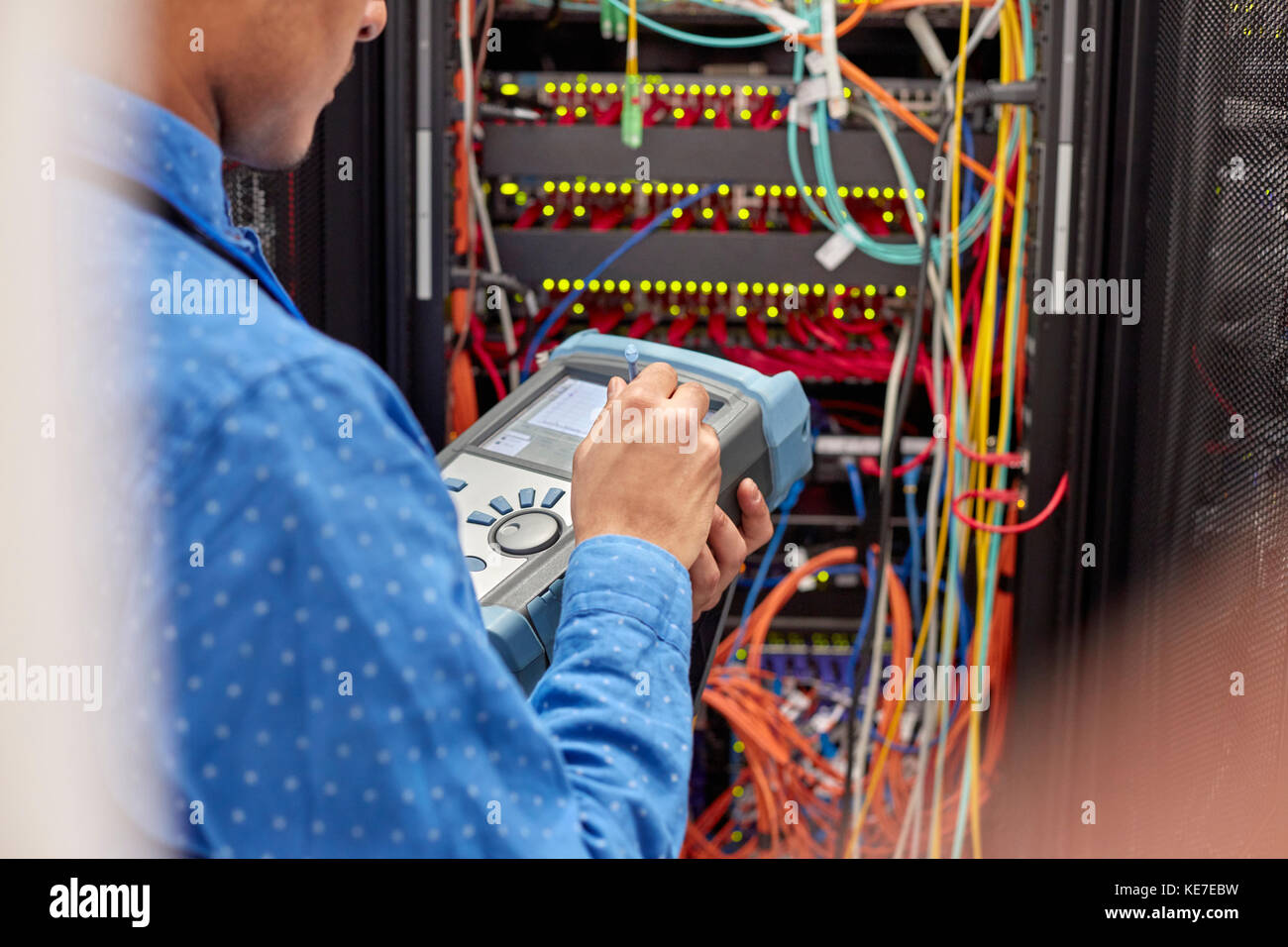 IT technician using fiber optic tester equipment in server room Stock