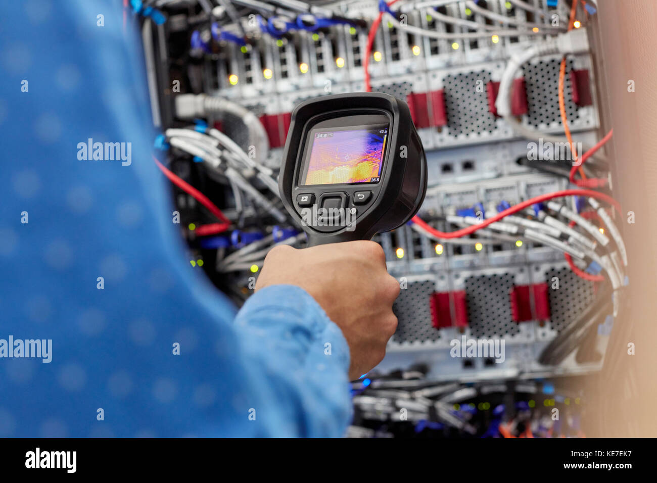 IT technician using diagnostic thermal imagining camera equipment in server room Stock Photo