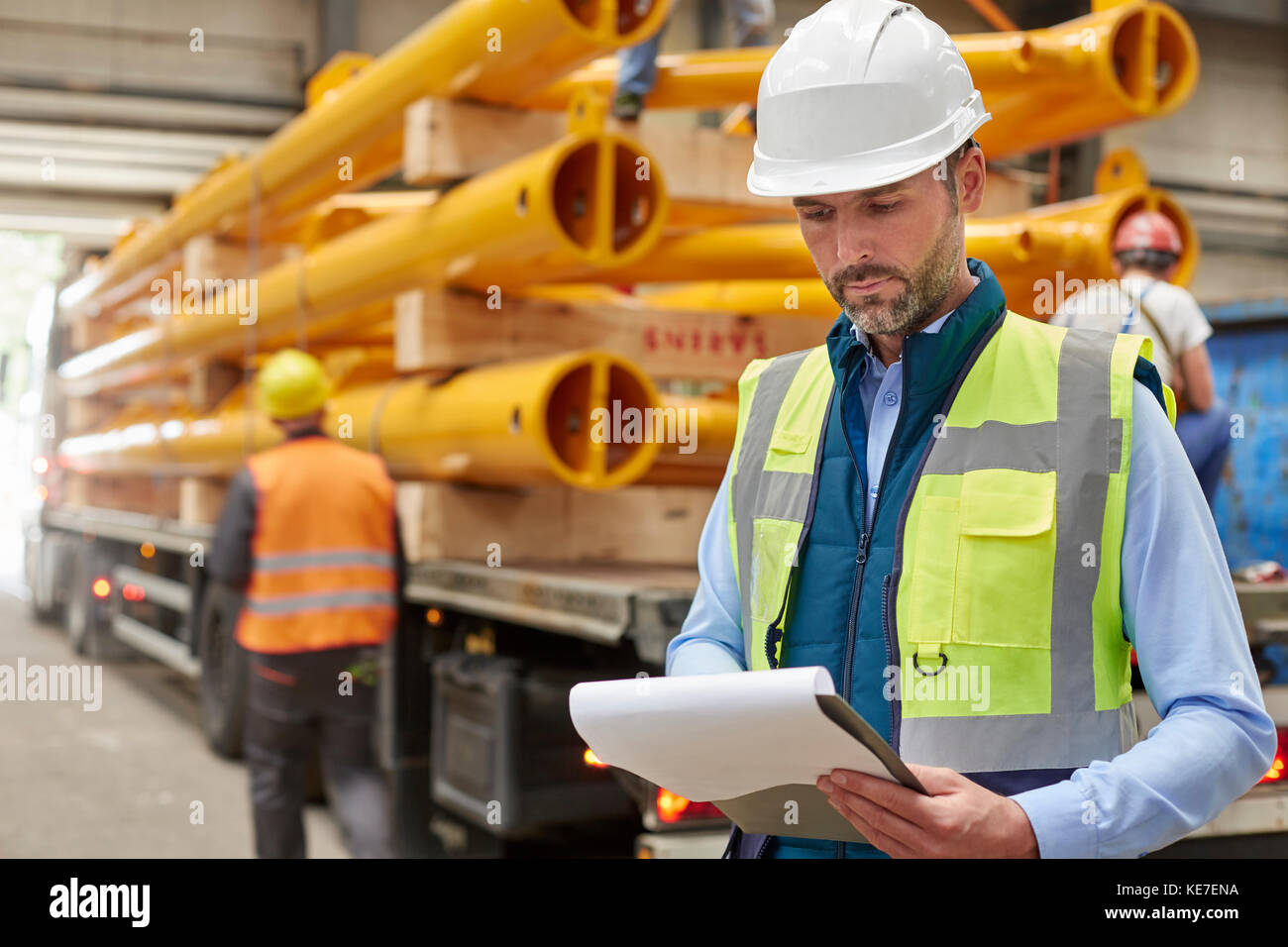 Filing Foreman Male foreman reading paperwork on clipboard in factory Stock Photo - Alamy