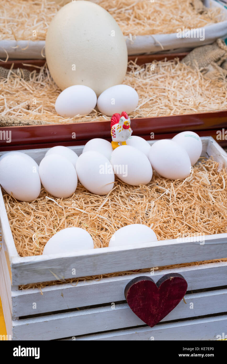 White chicken eggs leaning on straw in wooden basket Stock Photo - Alamy