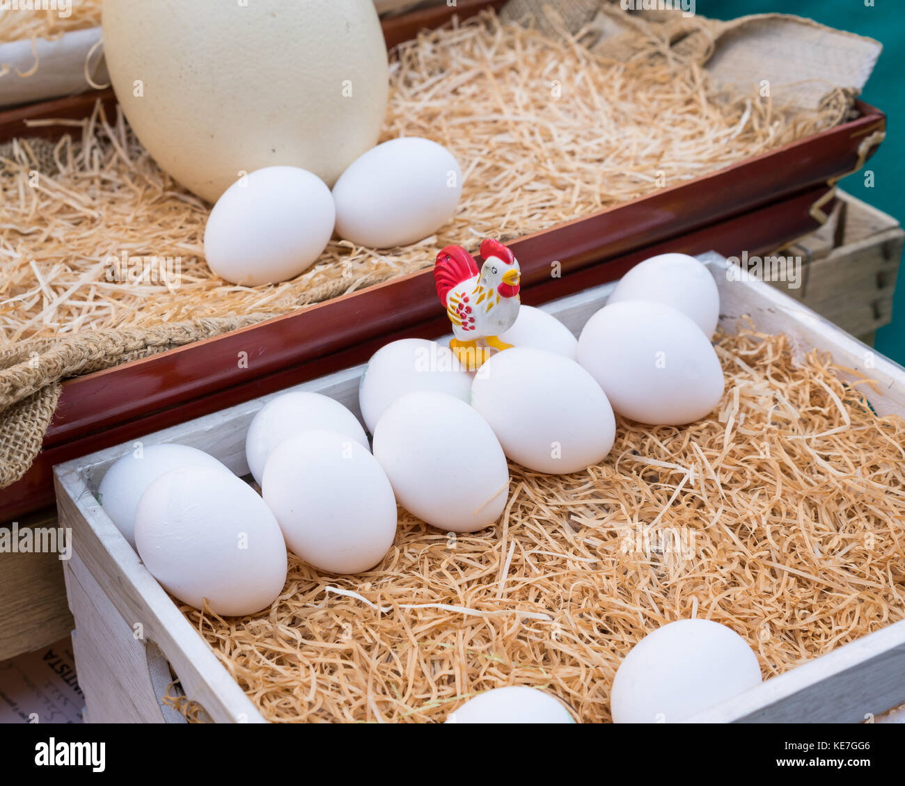 White chicken eggs leaning on straw in wooden basket Stock Photo - Alamy