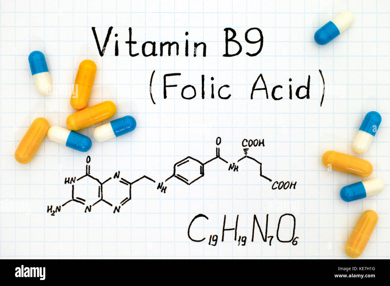Chemical formula of Vitamin B9 (Folic Acid) with pills. Close-up. Stock Photo
