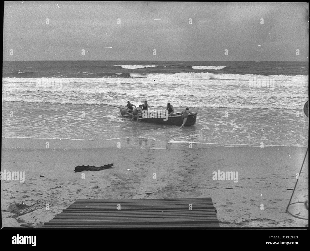 This historical photograph captures the launch of a Stockton surf boat, 'Up and Atom,' showcasing maritime activities and innovations in early 20th-century boat design. Stock Photo