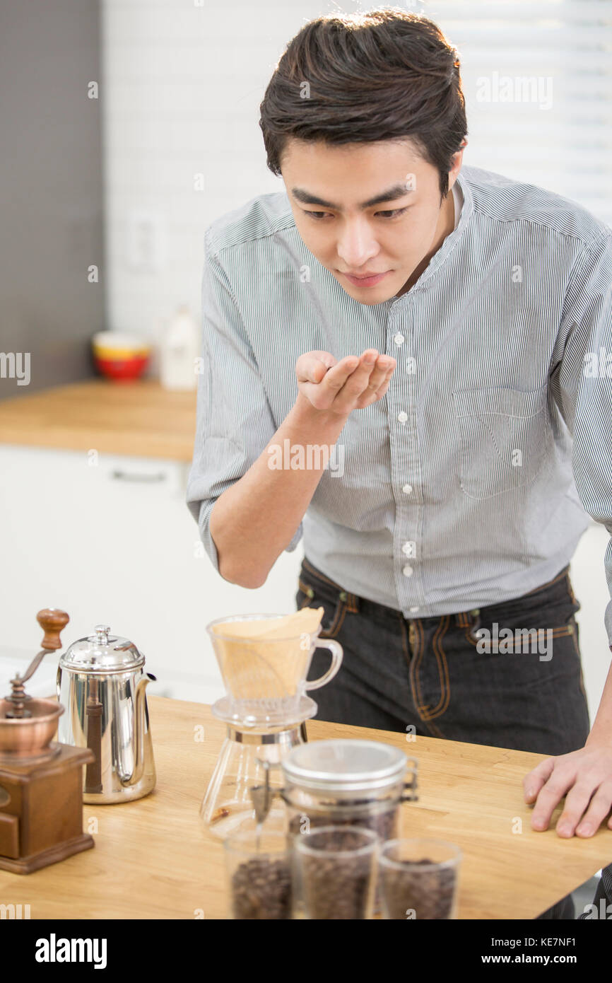Smiling single man smelling coffee at kitchen Stock Photo Alamy