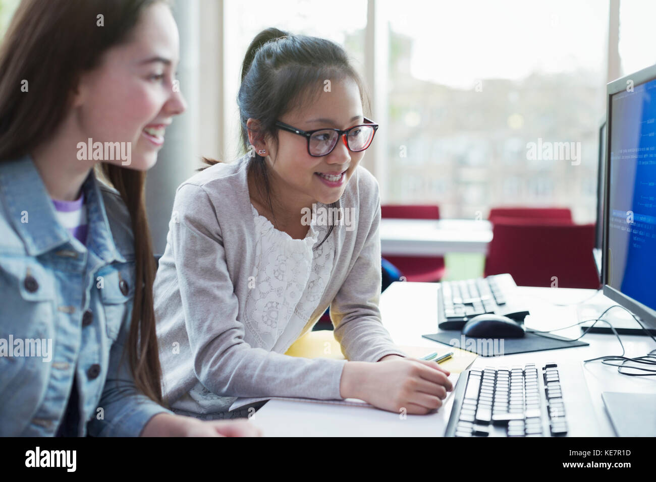 Girl students researching at computer in library Stock Photo - Alamy