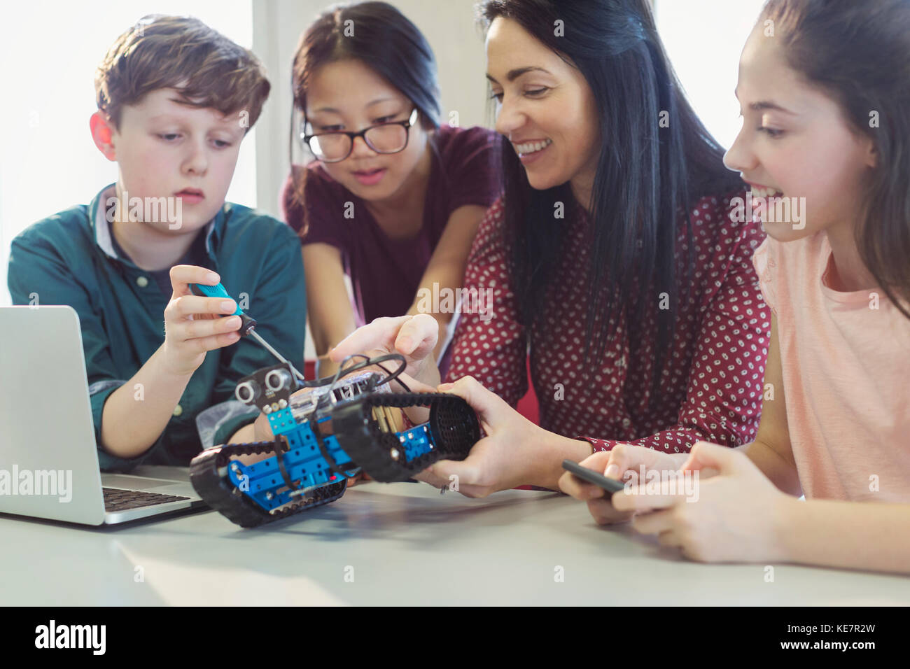 Female teacher and students programming and assembling robotics in classroom Stock Photo
