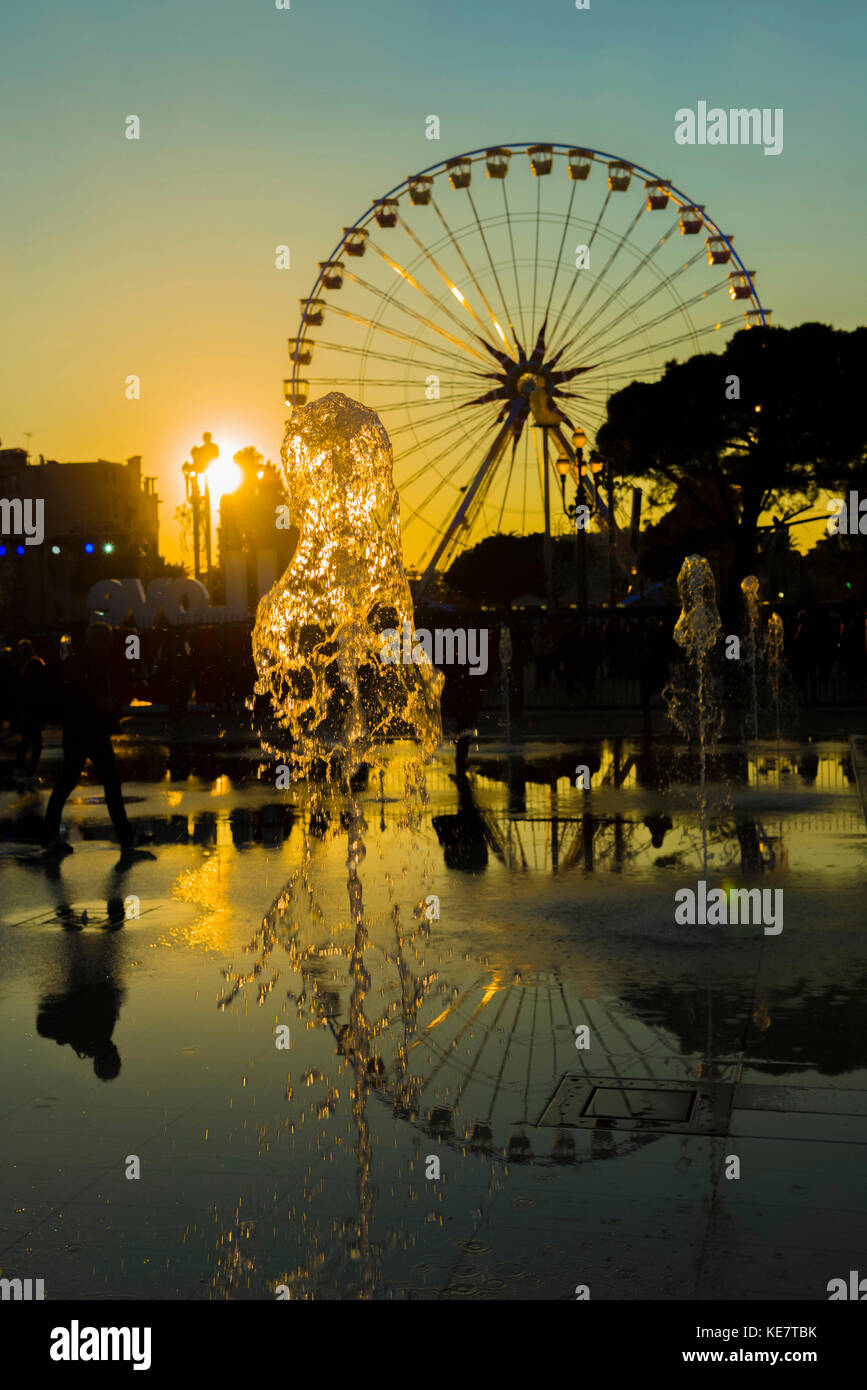 Fountain And A Ferris Wheel At Sunset Reflected In Water, Place Massena; Nice, Cote D'azur, France Stock Photo