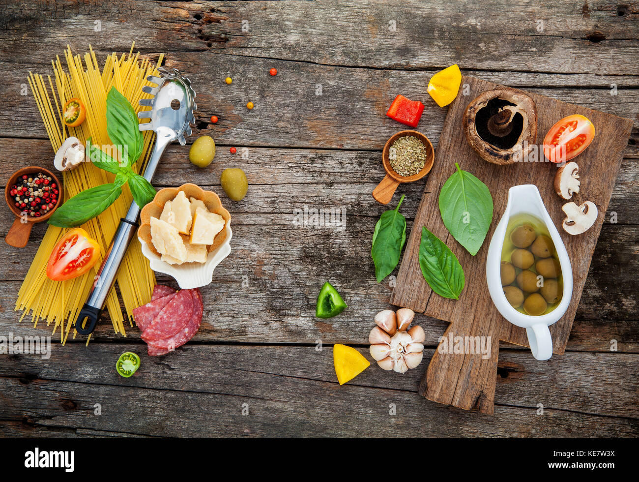 The ingredients for homemade pasta basil, parmesan cheese ,garlic, olive oil , ,peppercorn ,mushroom on shabby wooden background with flat lay . Stock Photo