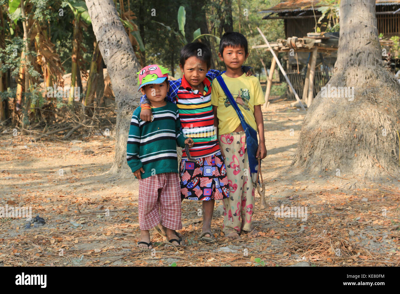 Nyaunghtaw Village is on the left (east) bank of the Irrawaddy River in Ayeyarwaddy province in Myanmar (Burma). Three boys posing for camera. Stock Photo
