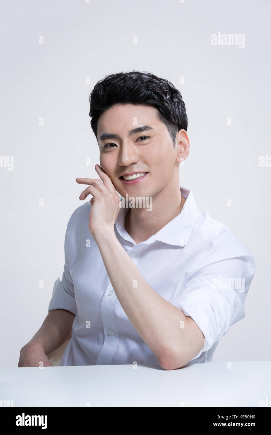 Portrait of young smiling grooming in white shirt posing Stock Photo
