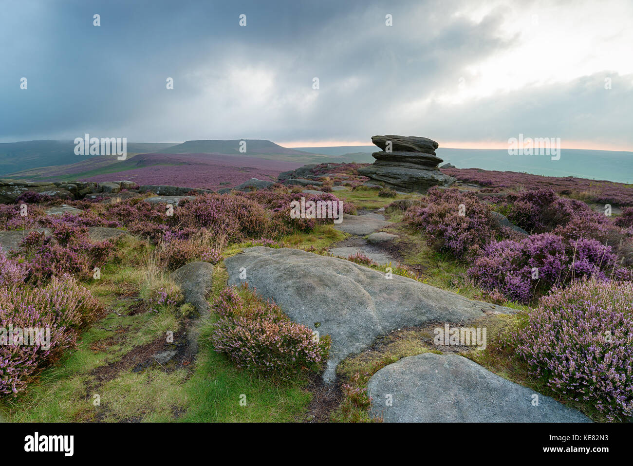 Stormy sunrise over rock formations at Over Owler Tor in Derbyshire, looking out over Winyards Nick with Higger Tor in the distance Stock Photo