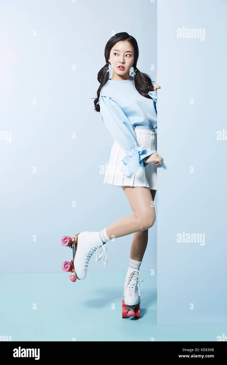 Young woman in roller skates posing on one foot looking aside Stock Photo