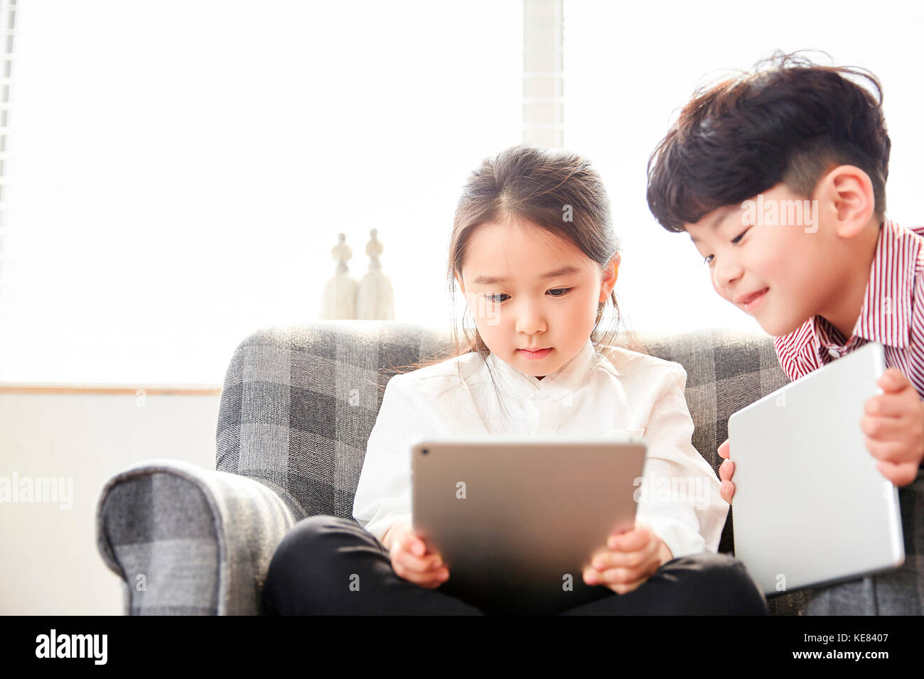 Smiling boy and girl using electric tablets Stock Photo Alamy