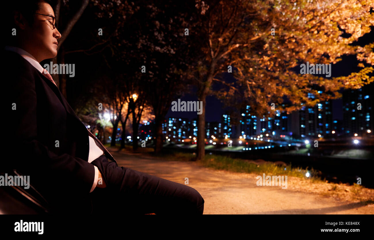 Businessman tired and gloomy in city at night Stock Photo