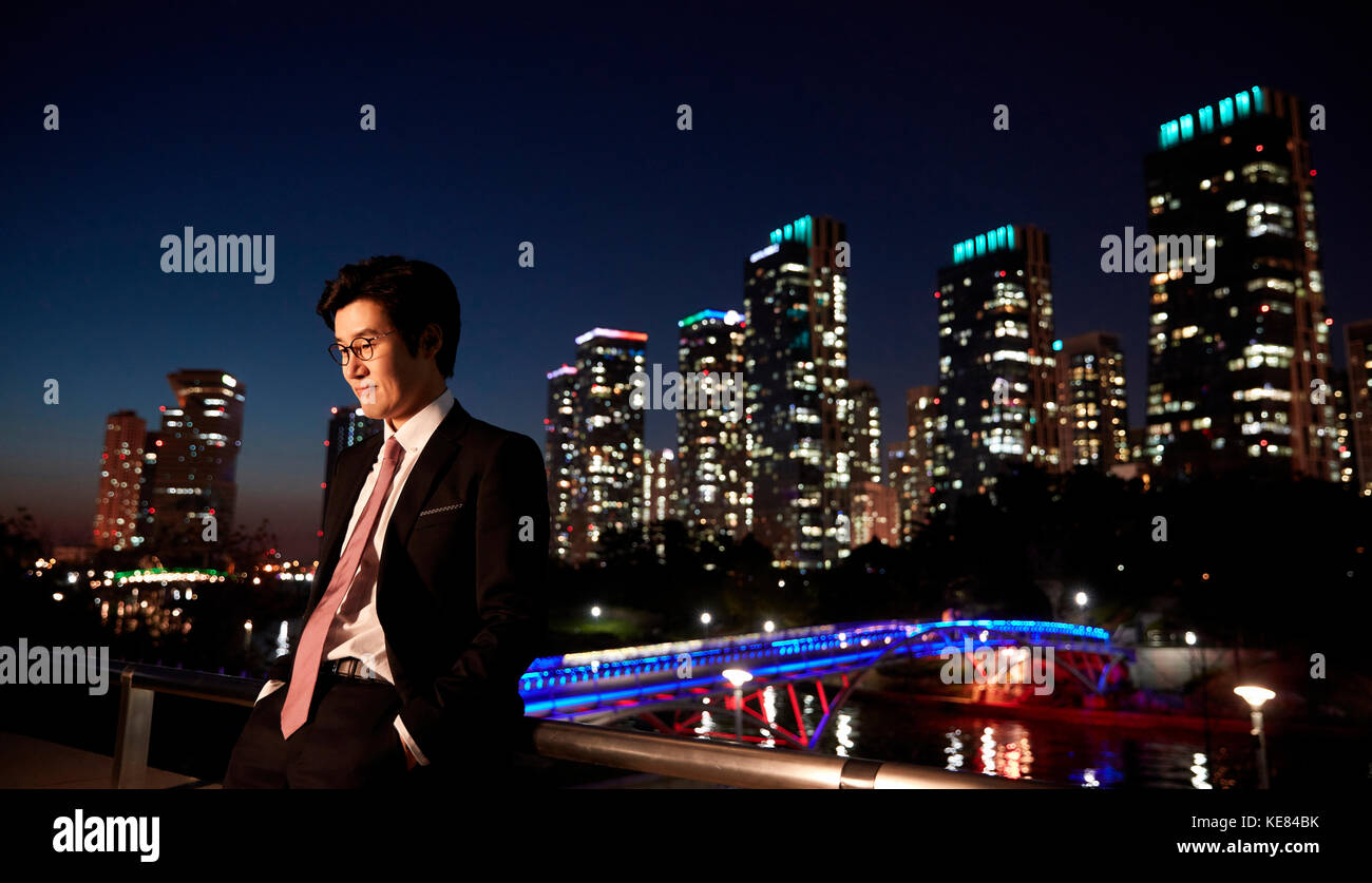 Businessman standing against night view of city Stock Photo - Alamy