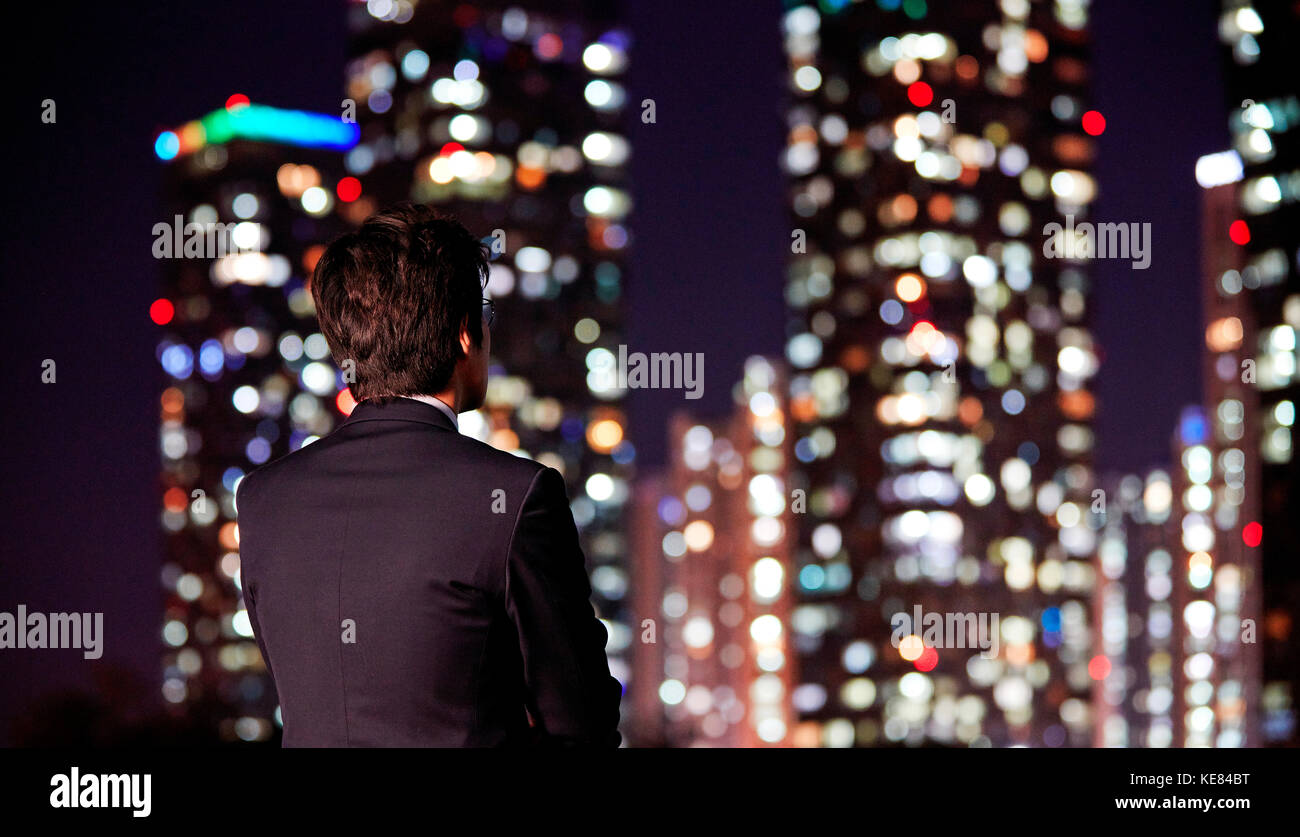 Back of businessman watching night view of city Stock Photo