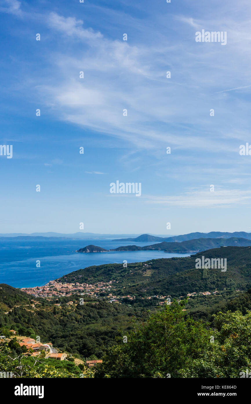Vertical view down on small town Marciana Marina on the coast of Elba island in Mediterranean sea. The hills and mountains around are covered by trees Stock Photo